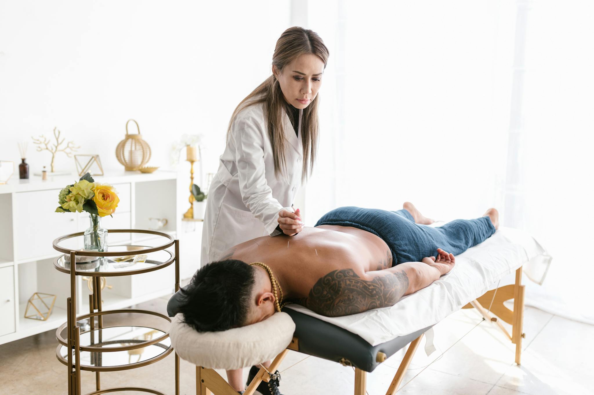 A therapist performs acupuncture on a patient in a serene wellness clinic setting.